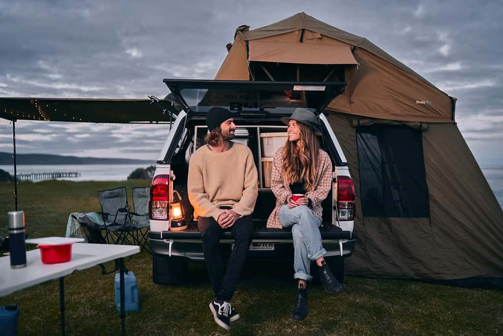 couple at the back of a 4wd campervan