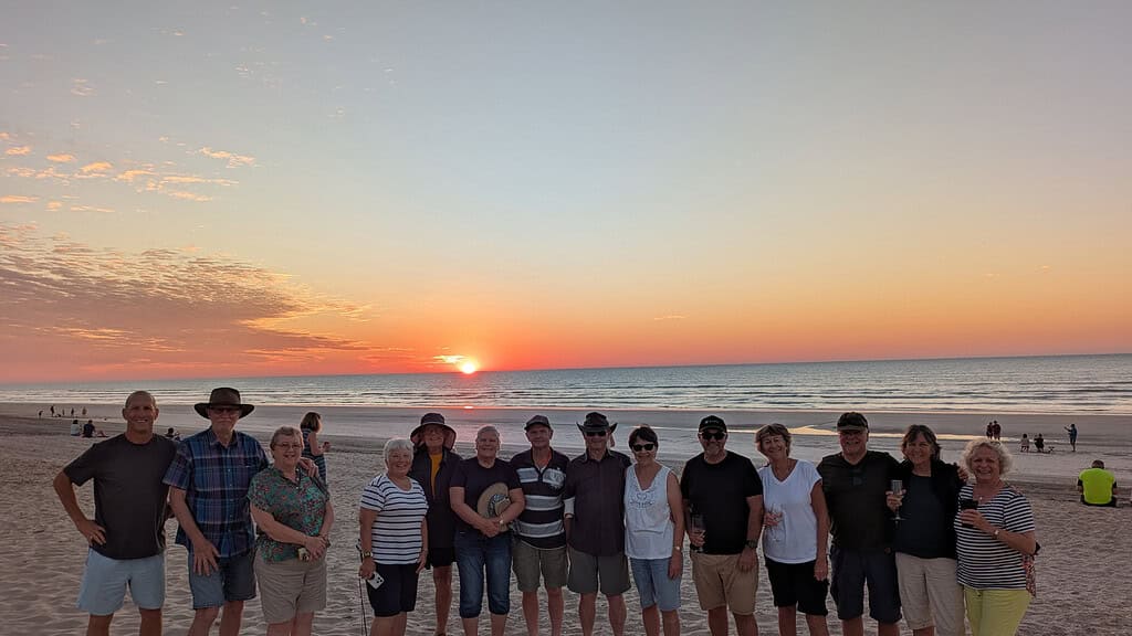 Travellers on an escorted motorhome tour enjoying sunset on the beach