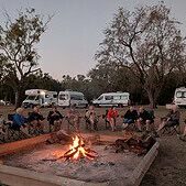 Escorted motorhome tour campfire Escorted motorhome tour group around a campfire with Maui motorhomes at camp